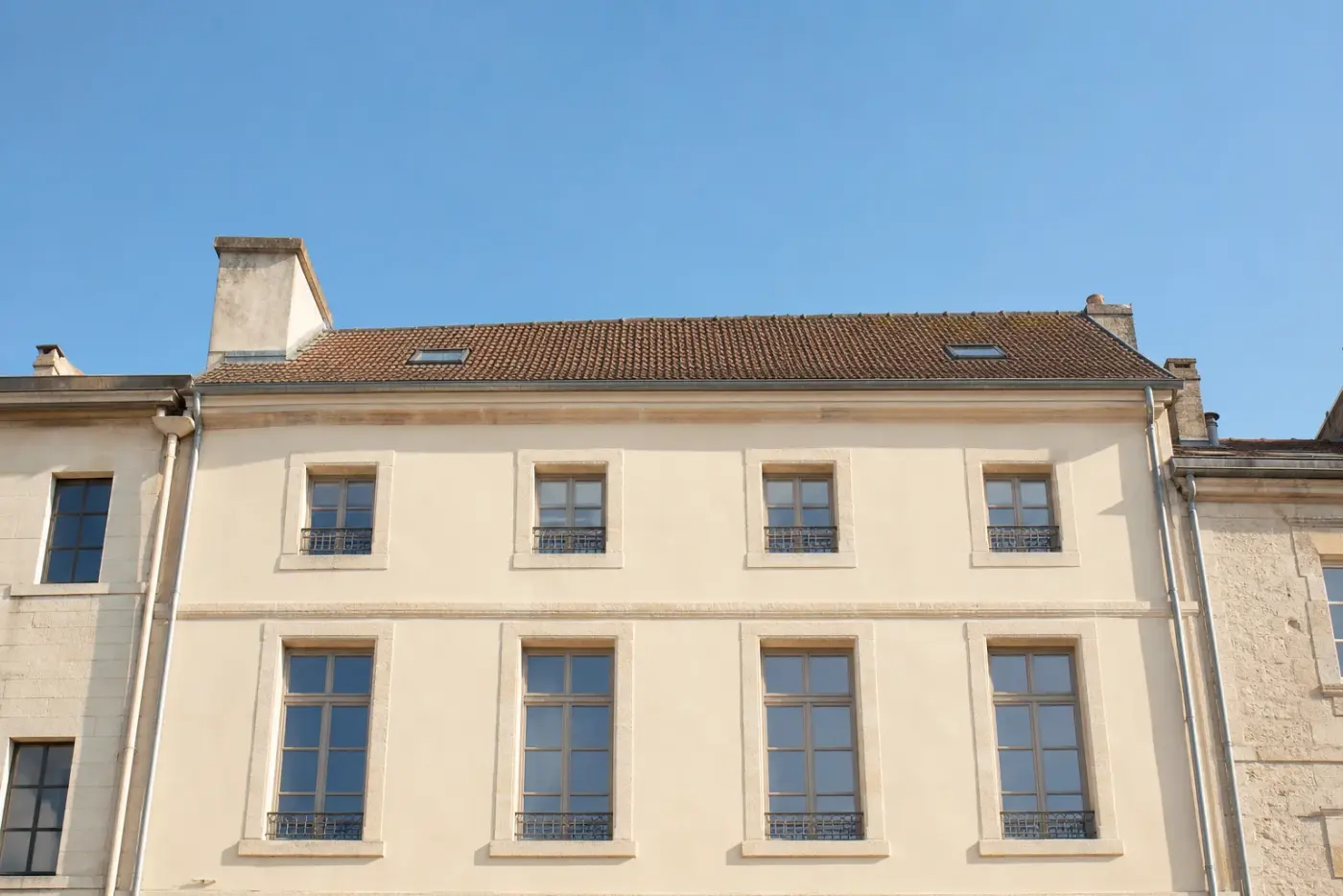 Façade d’immeuble ancien ravalée avec un enduit à la chaux clair