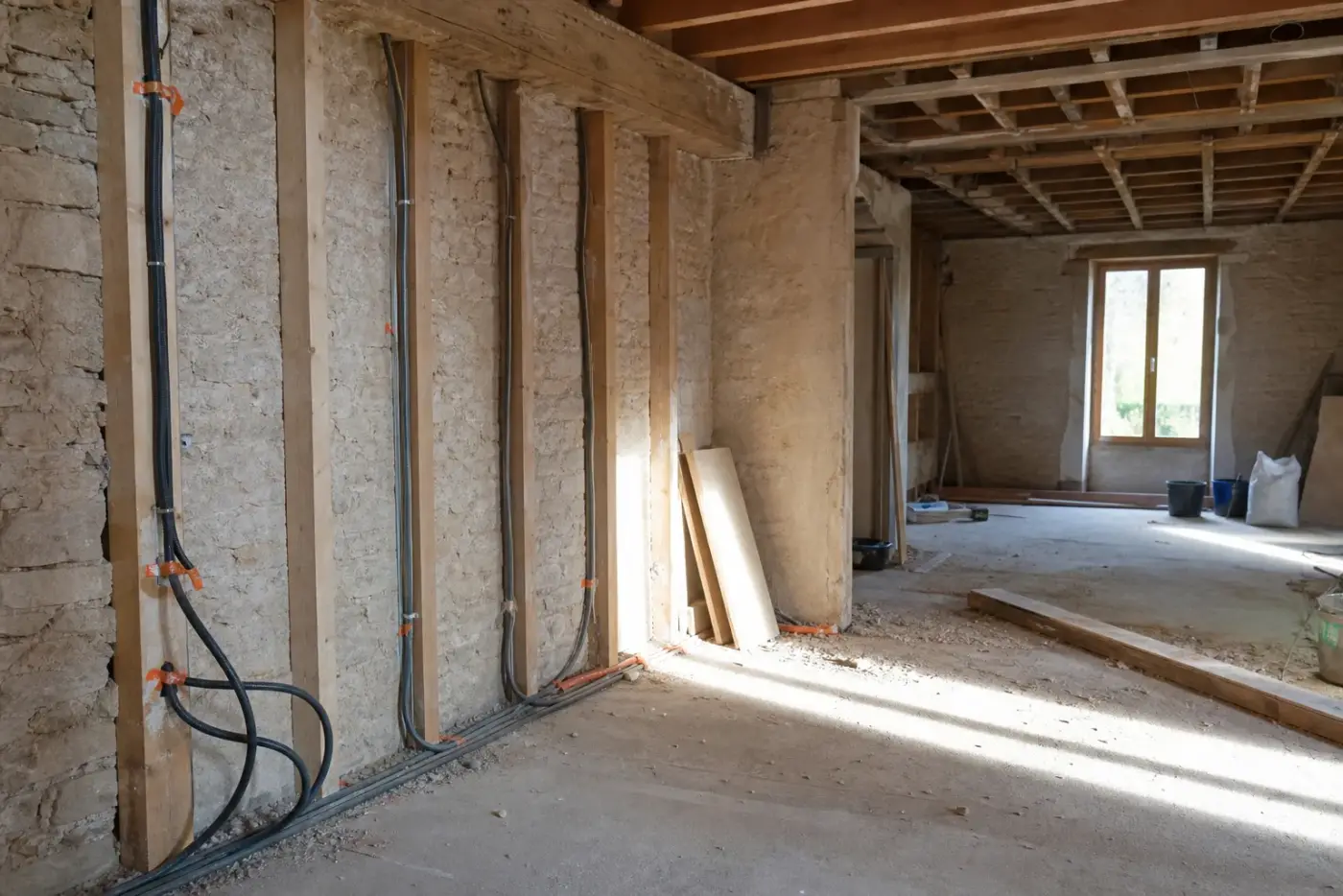 Intérieur de maison en cours de rénovation, cloisons ouvertes et réseaux apparents