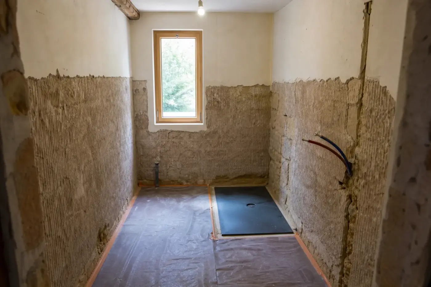 Salle de bain en cours de rénovation avec arrivées d'eau en attente