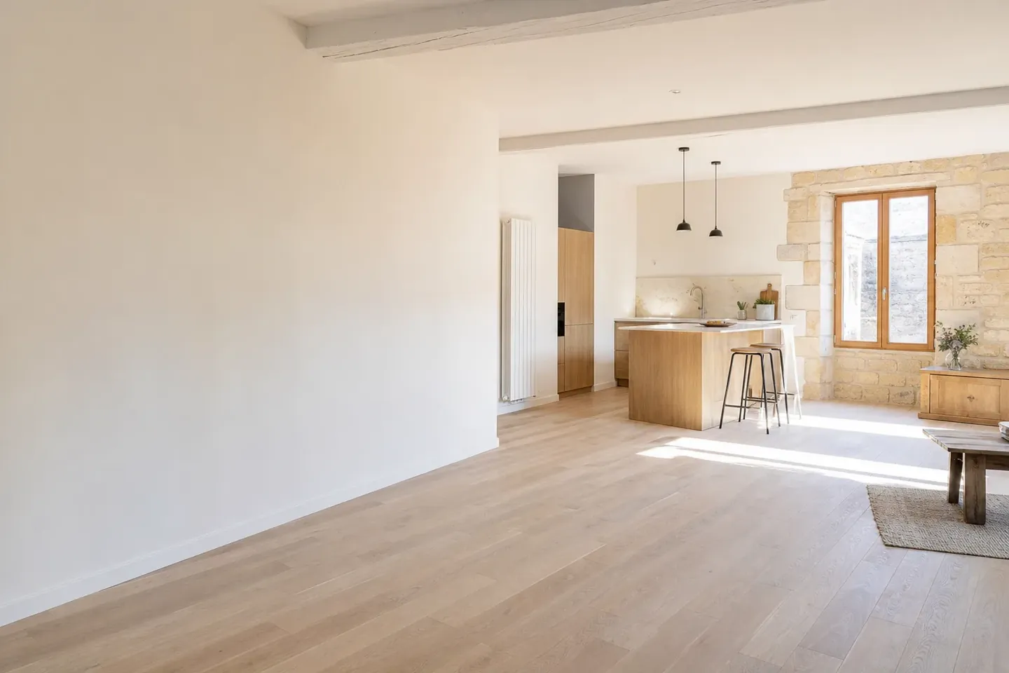Séjour d’appartement rénové avec cuisine ouverte et parquet clair